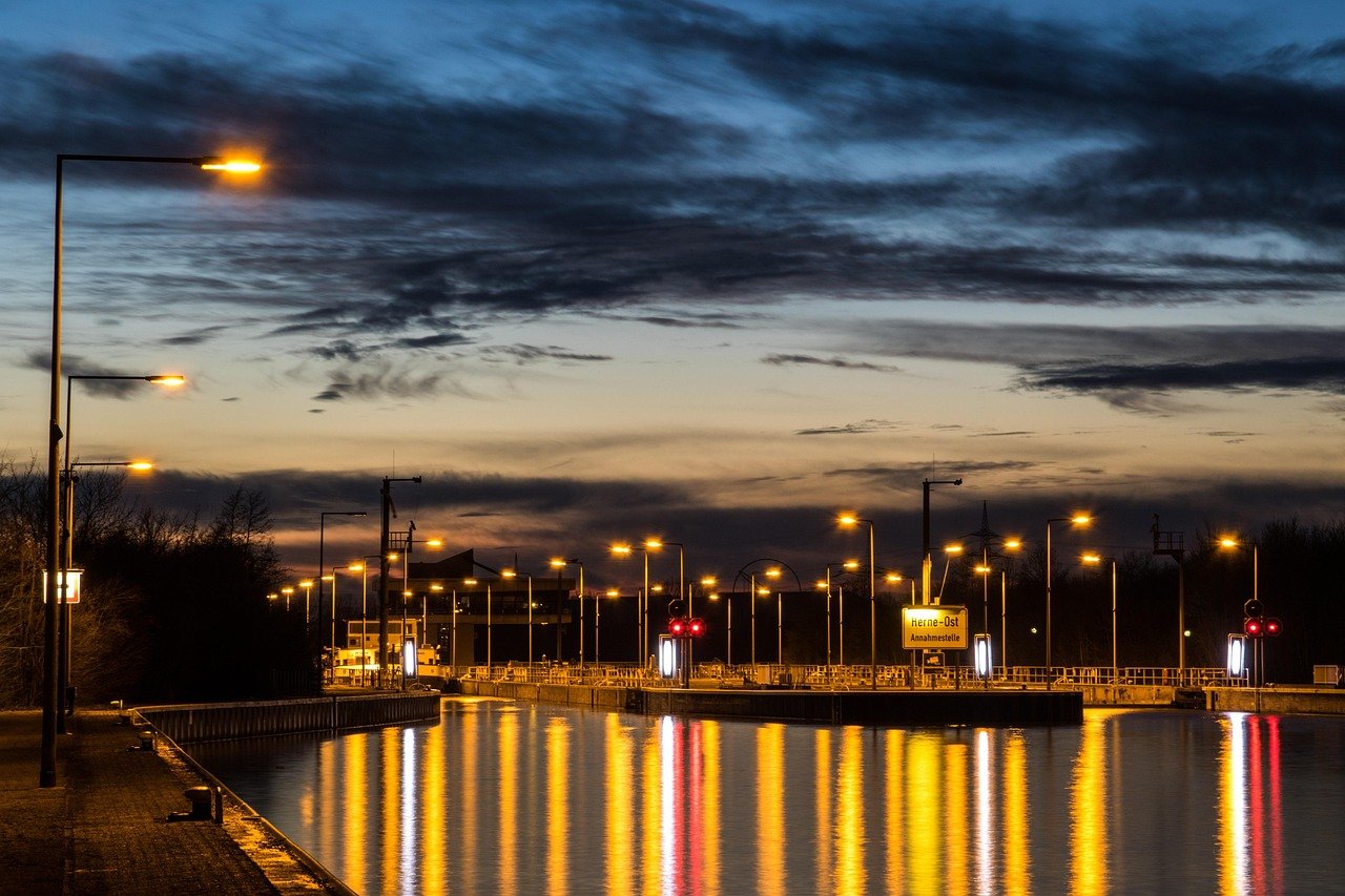 Beleuchtete Schleuse am Herne-Ost-Kanal bei Abenddämmerung als Stadtbild Herne für professionelle Übersetzungen