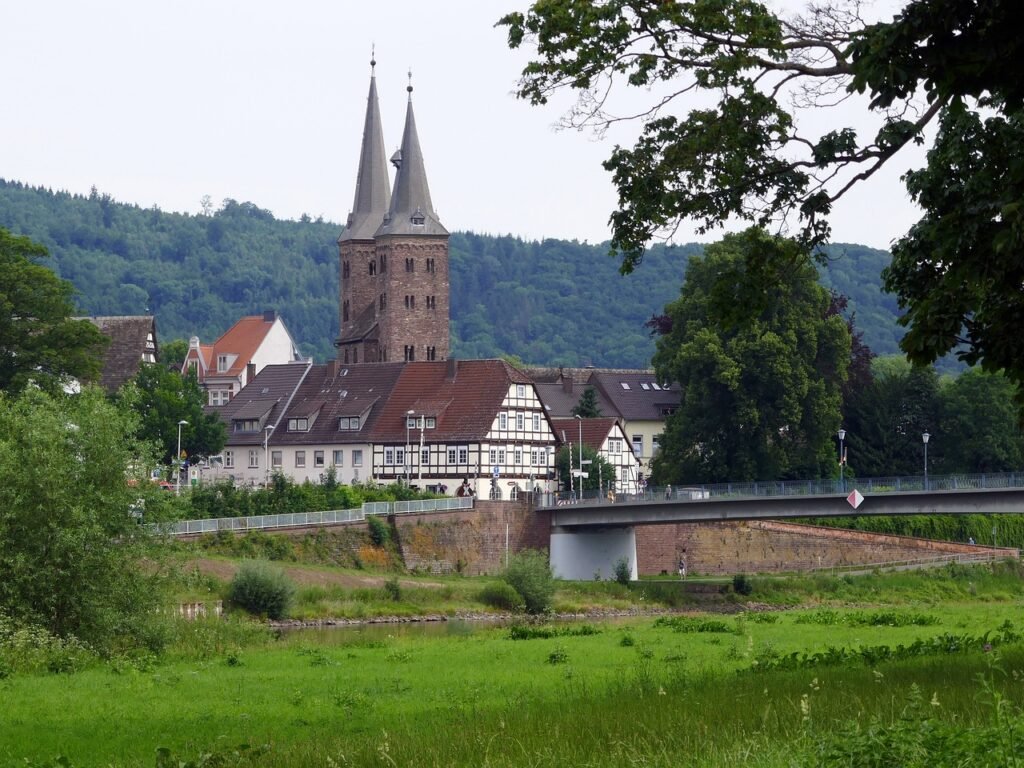 Historische Kirche in Höxter mit Fachwerkhäusern und Weserlandschaft – regionaler Bezug für Übersetzungen in Höxter.