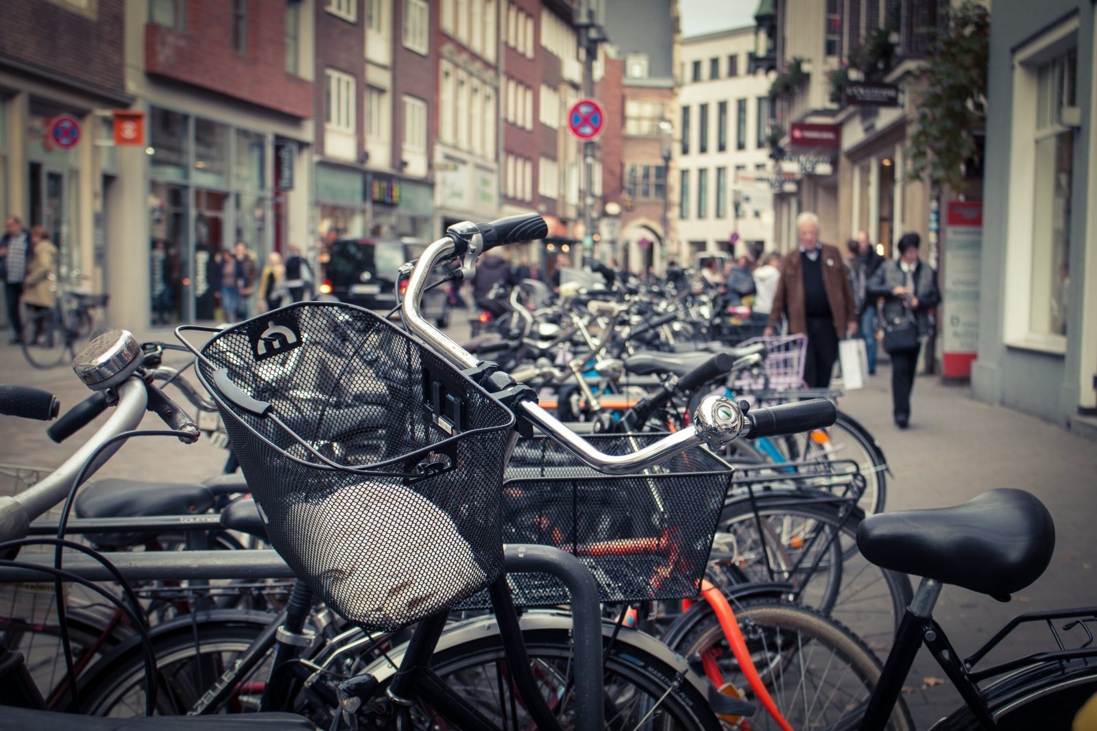 Fahrräder in der Altstadt von Münster mit Fußgängern im Hintergrund als regionaler Bezug zu Übersetzungen in Münster